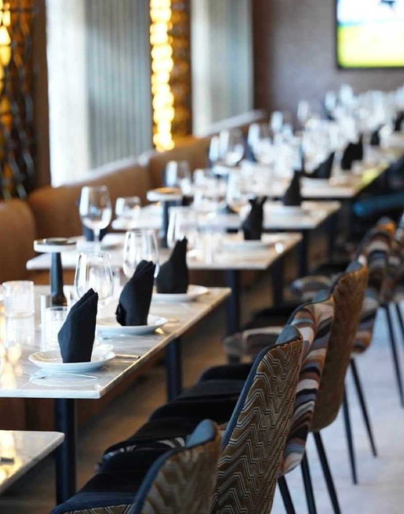 Salón principal del restaurante Coqué con mesas puestas y luces doradas